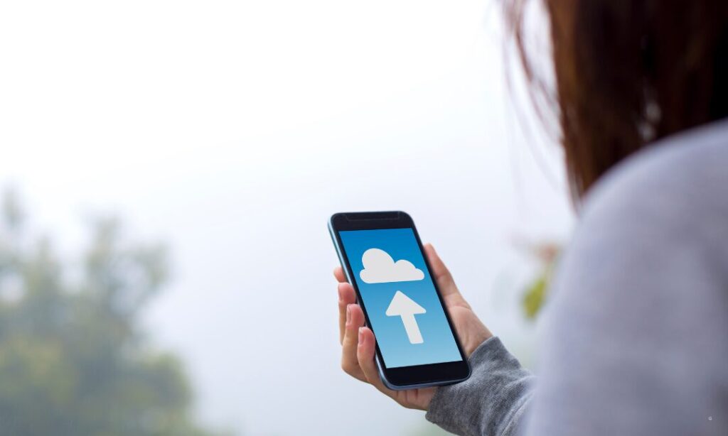 スマホを片手にバックアップ画像を見ている女性