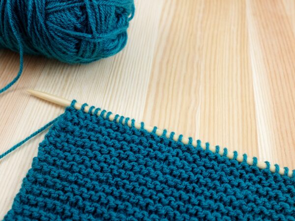 青い毛糸と棒針編みのガーター編み